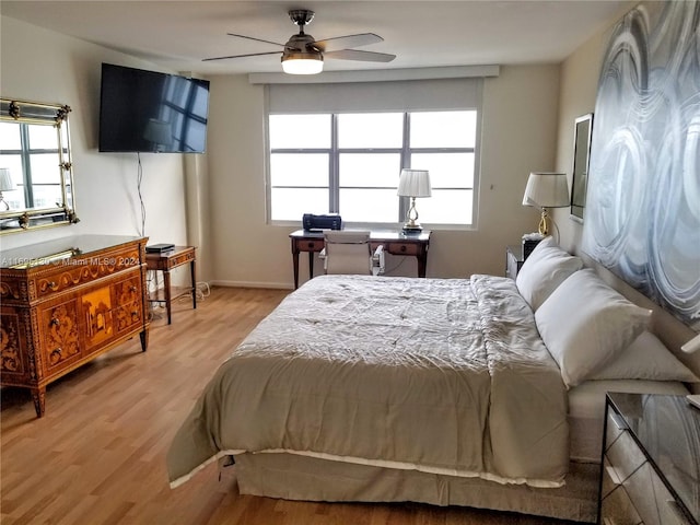 bedroom featuring light wood-type flooring, multiple windows, and ceiling fan