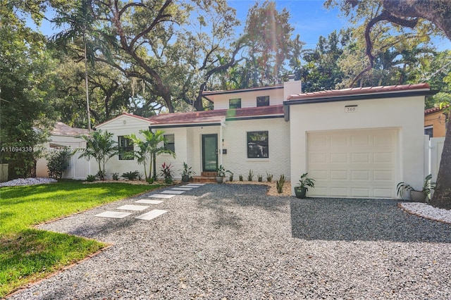 mediterranean / spanish house with a garage and a front yard