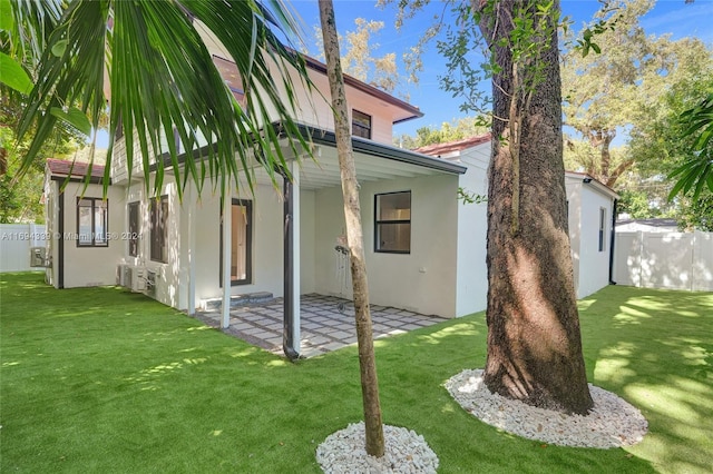 back of property with a yard and a patio