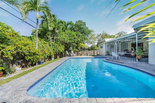 view of swimming pool featuring ceiling fan and a patio area