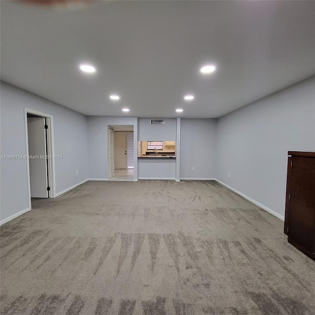 unfurnished living room featuring light colored carpet