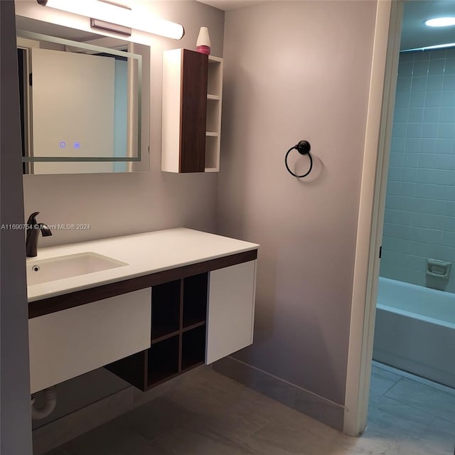 bathroom with tile patterned floors, vanity, and tiled shower / bath combo