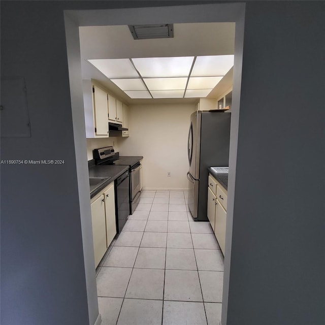 kitchen with light tile patterned flooring, white cabinets, a drop ceiling, and black appliances