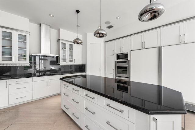 kitchen with a center island, wall chimney exhaust hood, decorative backsplash, decorative light fixtures, and stainless steel appliances