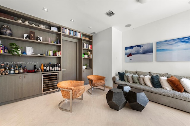 living room with light hardwood / wood-style floors, beverage cooler, and bar area