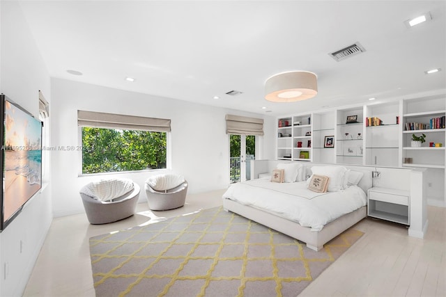 bedroom featuring white fridge and light hardwood / wood-style floors