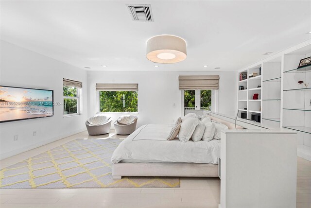 bedroom featuring multiple windows and light hardwood / wood-style flooring