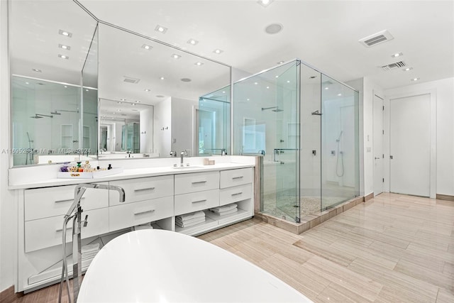 bathroom featuring vanity and independent shower and bath