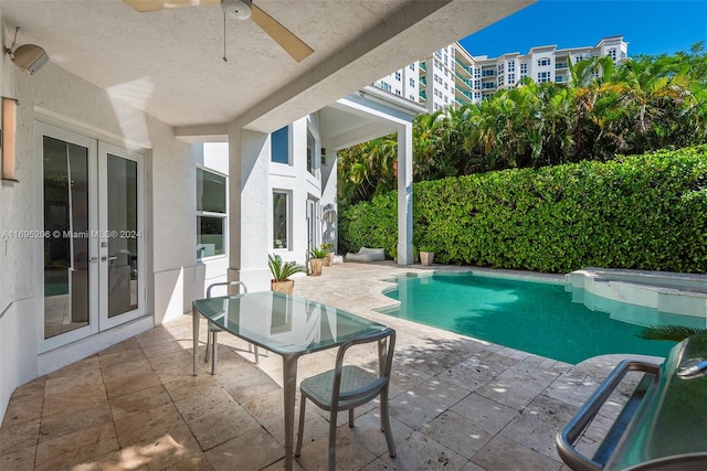 view of swimming pool featuring a patio area, ceiling fan, and french doors