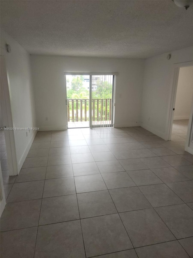 tiled spare room with a textured ceiling