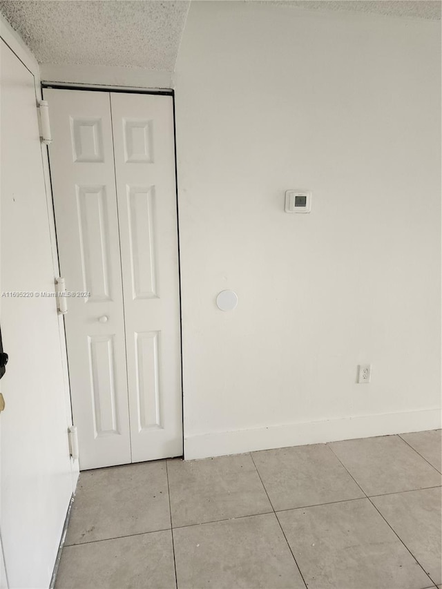 washroom featuring light tile patterned floors and a textured ceiling