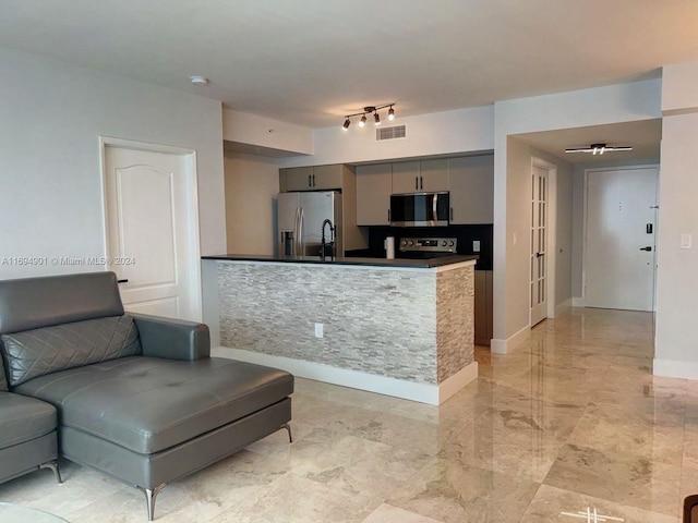 kitchen with stainless steel appliances, gray cabinetry, and sink