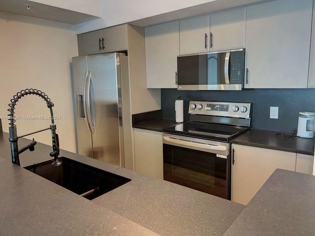 kitchen with decorative backsplash, sink, and stainless steel appliances