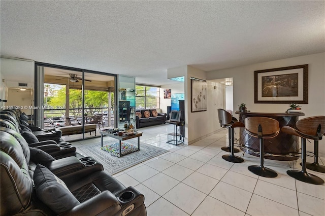 tiled living room featuring a textured ceiling, floor to ceiling windows, and a healthy amount of sunlight