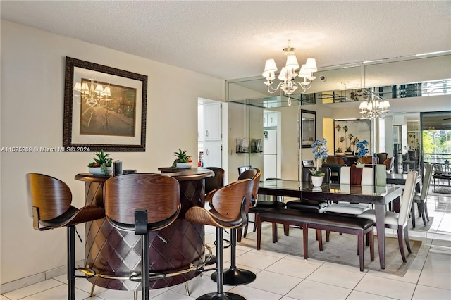 tiled dining room featuring a textured ceiling and an inviting chandelier