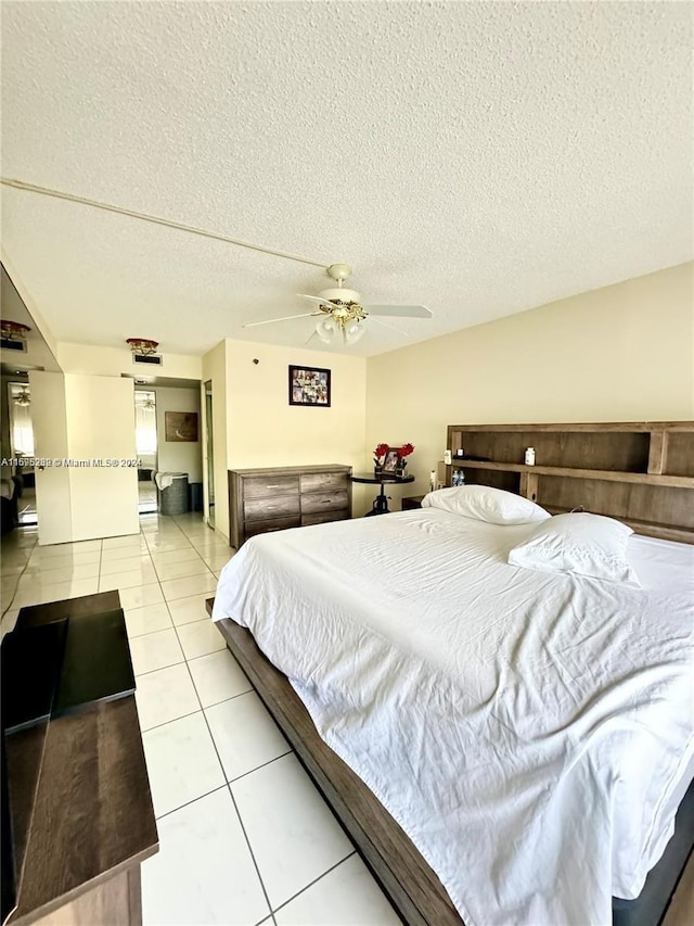 bedroom featuring light tile patterned floors, a textured ceiling, and ceiling fan