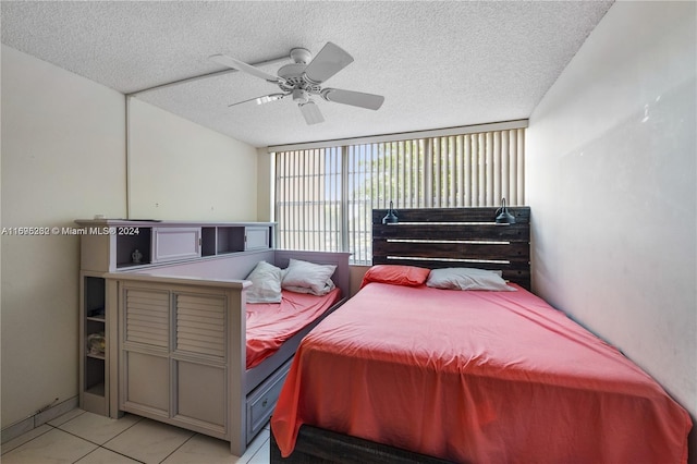 tiled bedroom featuring a textured ceiling and ceiling fan