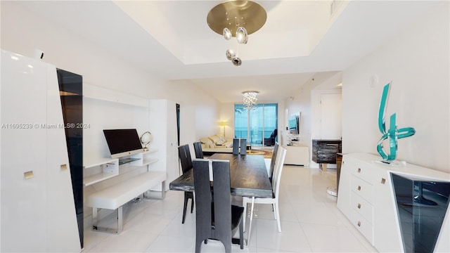 tiled dining space with a raised ceiling