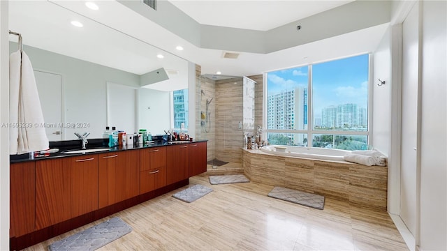 15811 Collins Ave Unit 504, Sunny Isles Beach, FL 33160 - bathroom featuring a stall shower, double vanity, a bath, recessed lighting, and a view of city