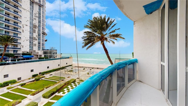 balcony featuring a water view and a view of the beach