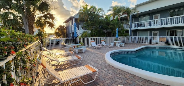 pool at dusk with a patio