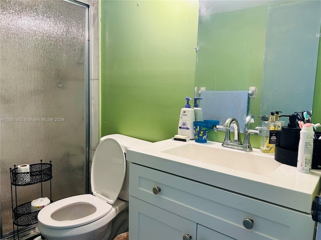 bathroom with vanity, toilet, and a shower with shower door