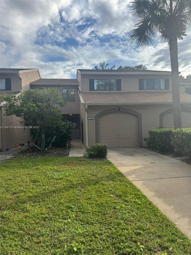 view of front of home with a front yard and a garage