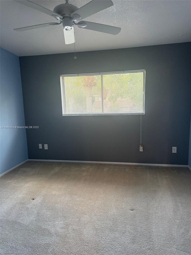 unfurnished room featuring ceiling fan, carpet, and a textured ceiling