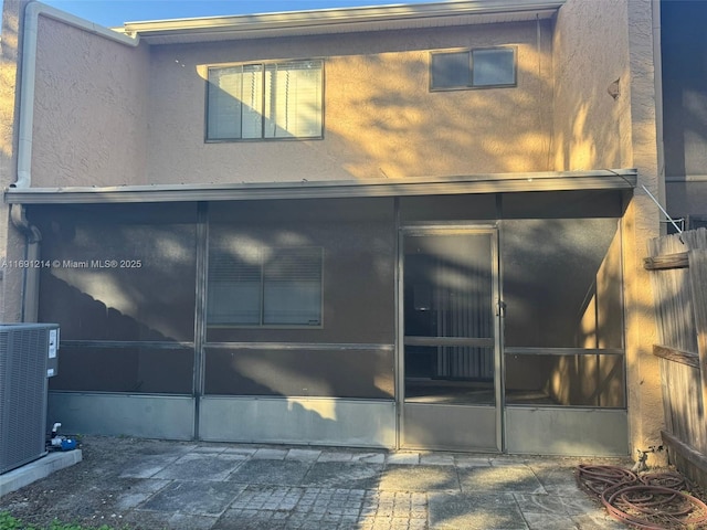 back of house featuring a sunroom and central air condition unit