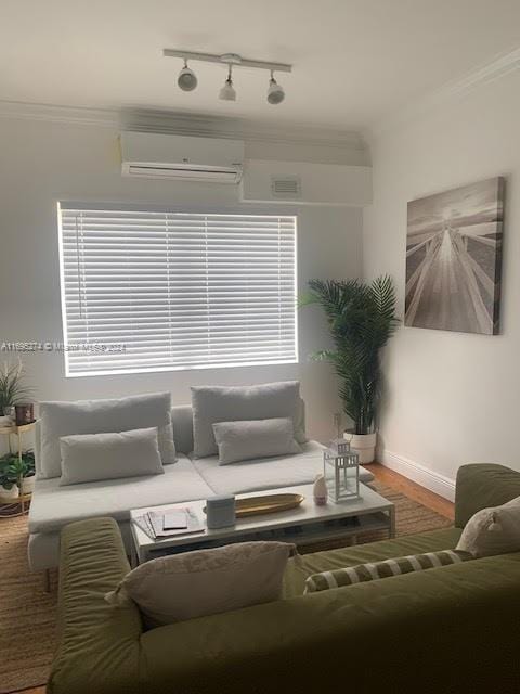 living room with hardwood / wood-style flooring, ornamental molding, a wall unit AC, and track lighting