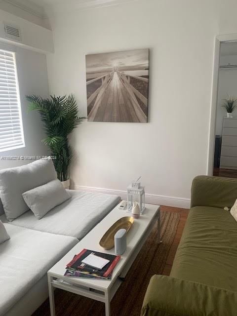 living room featuring hardwood / wood-style flooring and crown molding