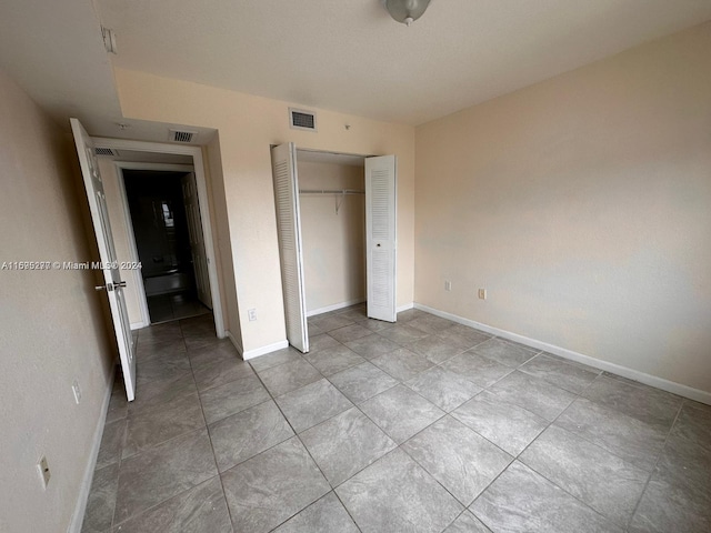 unfurnished bedroom featuring light tile patterned floors and a closet