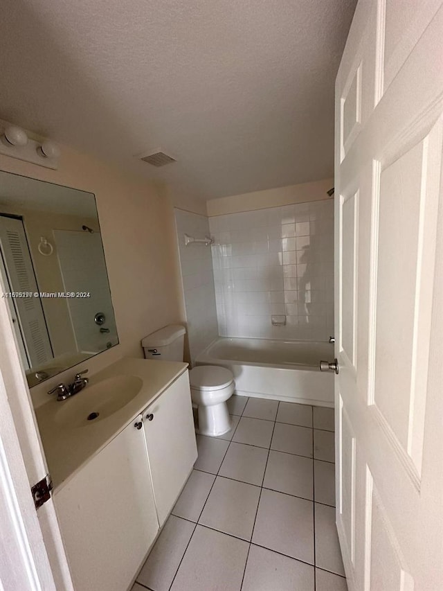 full bathroom featuring toilet, a textured ceiling, vanity, and tile patterned floors