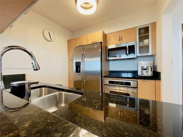 kitchen with sink, light brown cabinets, dark stone counters, and appliances with stainless steel finishes