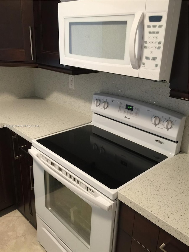 kitchen featuring dark brown cabinets and white appliances