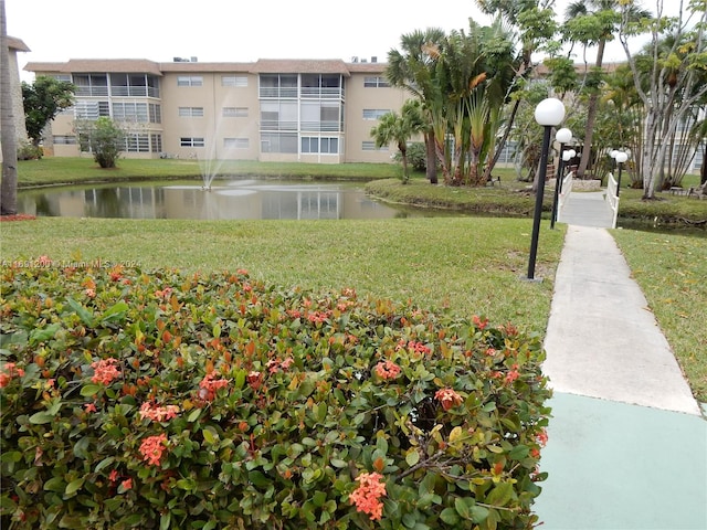 view of community featuring a water view and a lawn