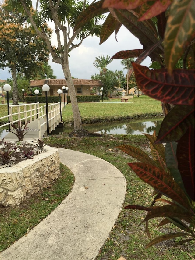 view of home's community with a lawn and a water view