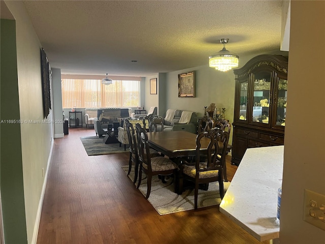 dining room with wood-type flooring and a textured ceiling