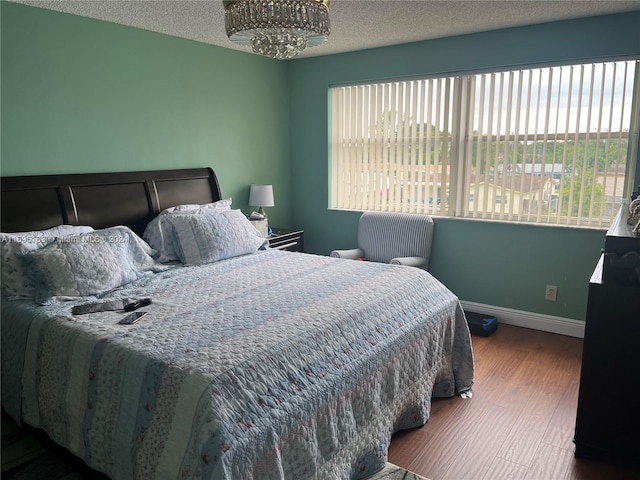 bedroom featuring a textured ceiling and dark hardwood / wood-style floors