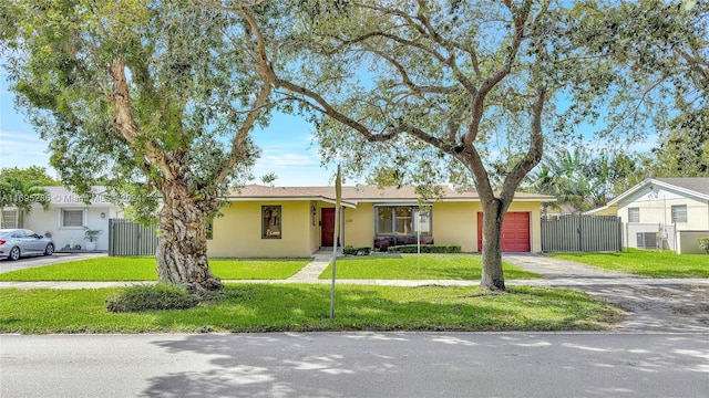 single story home with central AC unit, a front yard, and a garage