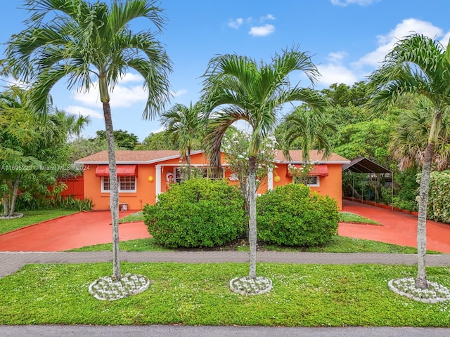 view of front of home with a carport and a front lawn