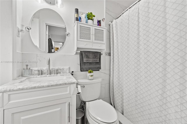 bathroom featuring vanity, tile walls, and toilet