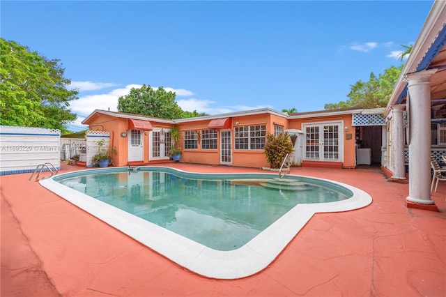 view of pool with french doors and a patio