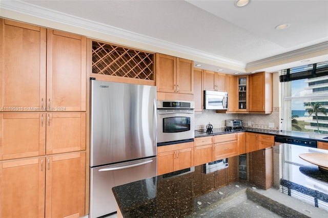 kitchen featuring a healthy amount of sunlight, dark stone countertops, ornamental molding, and stainless steel appliances