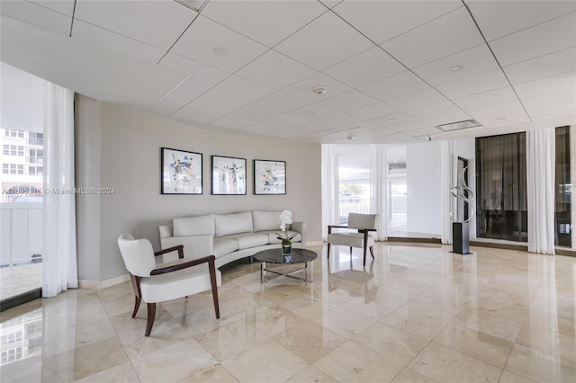 living room with a paneled ceiling