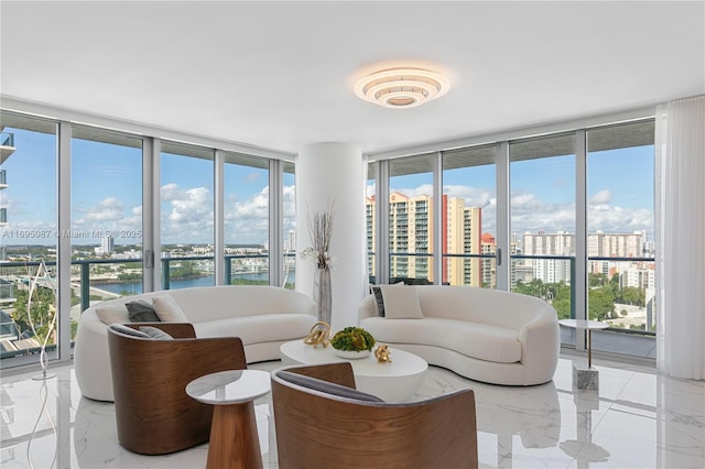 living area with expansive windows, marble finish floor, a city view, and a water view