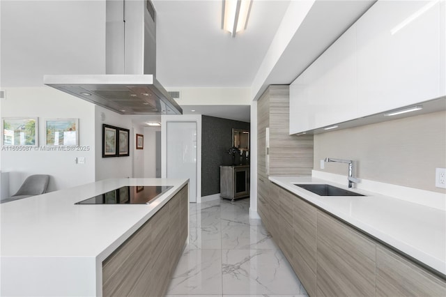 kitchen featuring marble finish floor, island exhaust hood, a sink, modern cabinets, and black electric cooktop