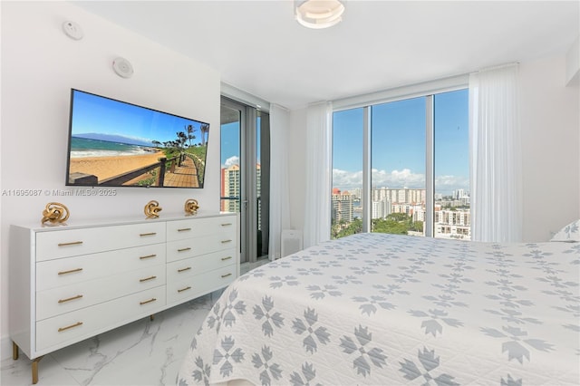 bedroom featuring marble finish floor and access to exterior