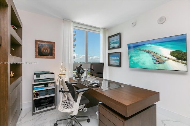 office with marble finish floor, floor to ceiling windows, and baseboards