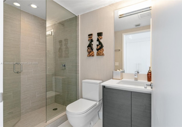 bathroom featuring visible vents, vanity, a shower stall, and toilet